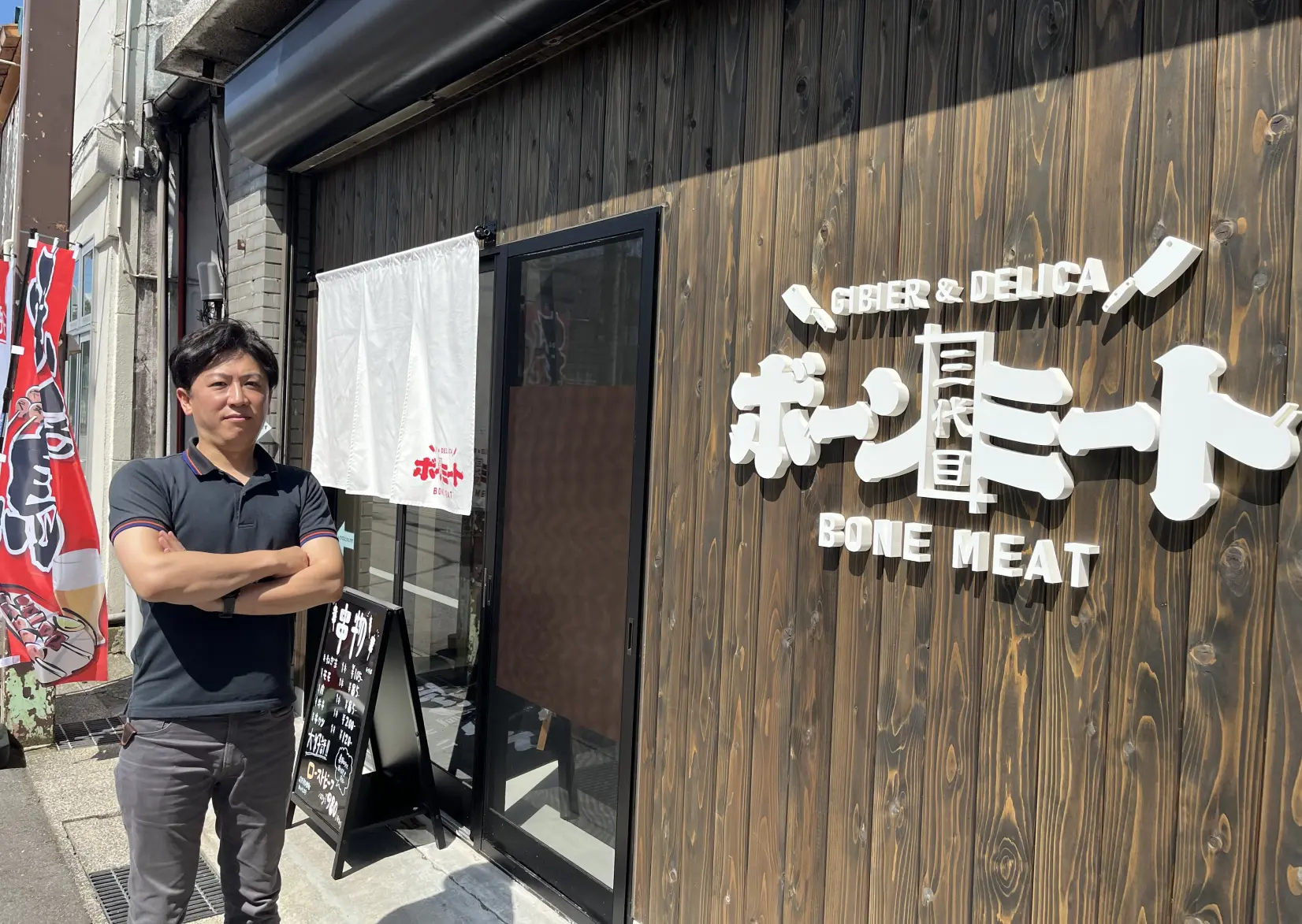 「三代目ボーンミート」の前で想いを語る経営者の河野京一さん