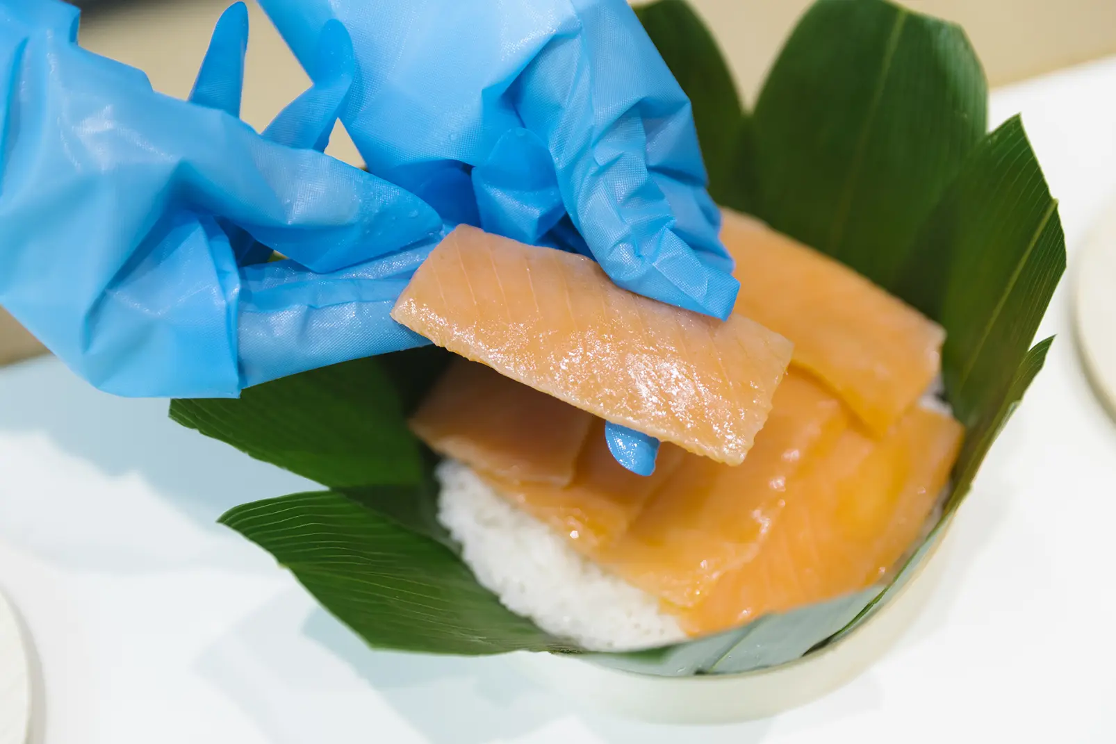 鮮やかなオレンジ色の鱒を、酢飯を隠すように並べる -1