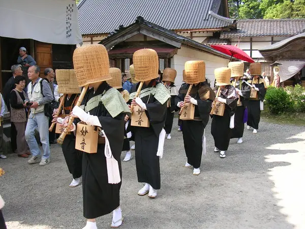 深編み笠をかぶり尺八を吹く不思議な光景
