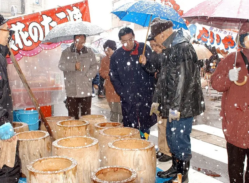 雪の中大勢の人で賑わう歳の大市